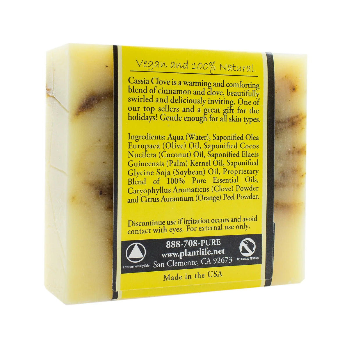 Rectangular bar of pale yellow soap with brown swirls, wrapped in a yellow label listing ingredients and details.