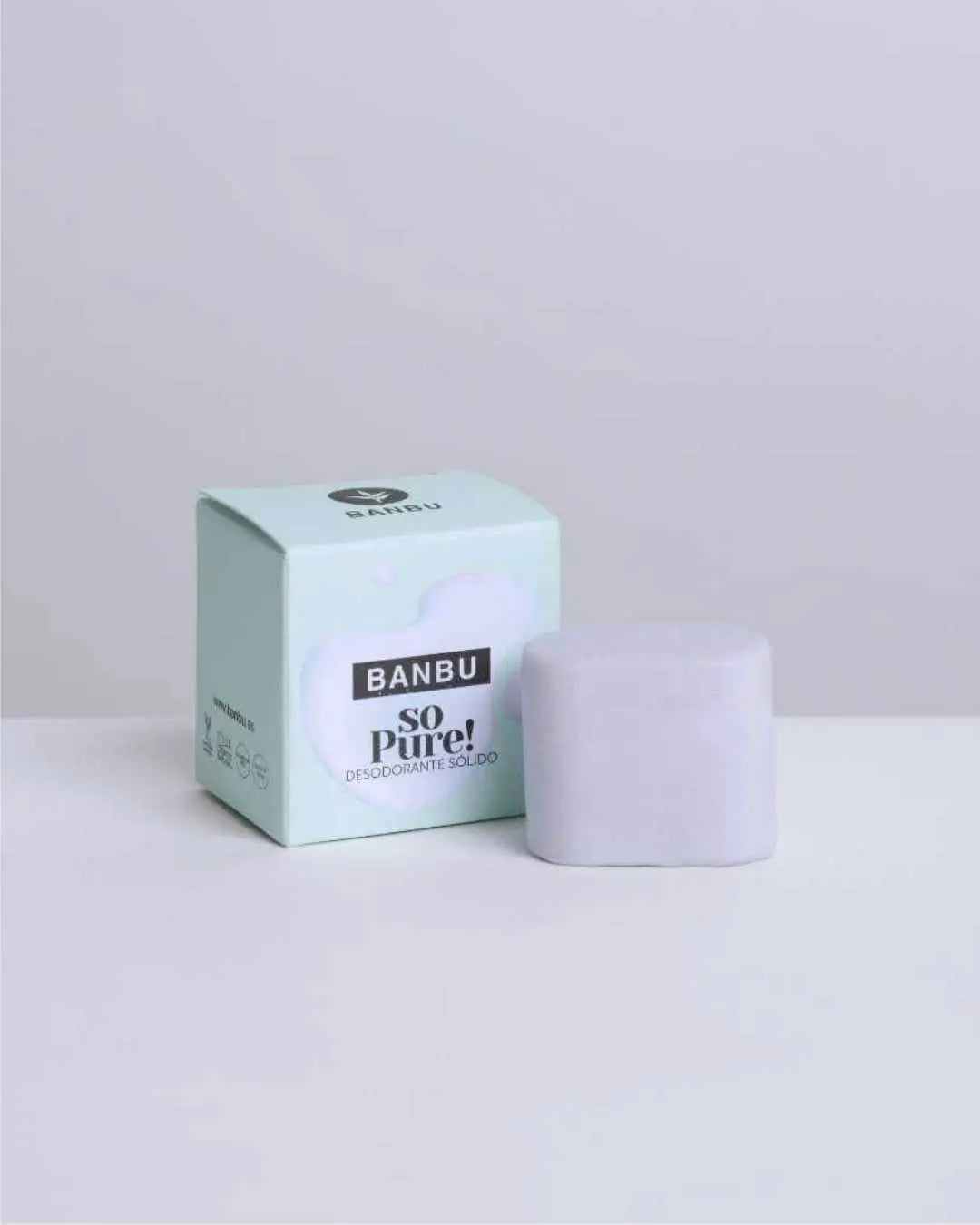 Desodorante sólido Banbu So Pure color lila junto a su caja de cartón verde menta sobre fondo minimalista.