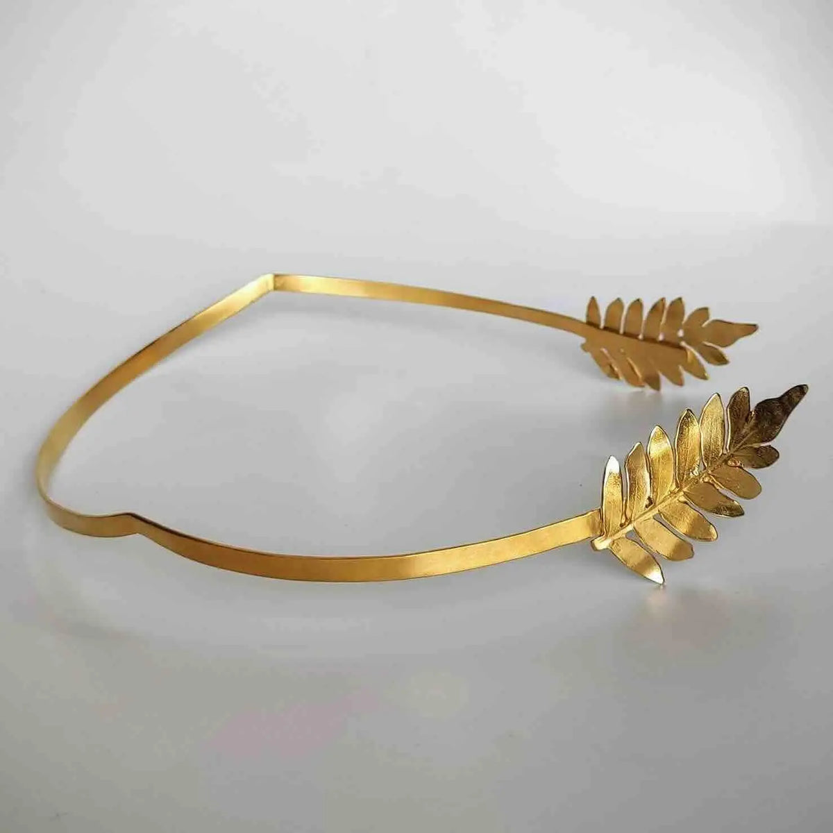 Diadema dorada de metal con diseño de hojas, elegante y contemporánea para un look sofisticado.