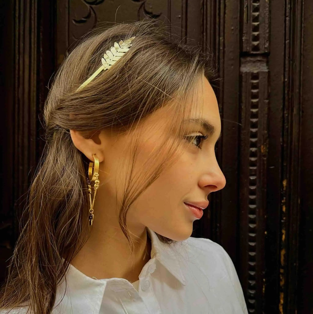 Diadema blanca con diseño de hoja, elaborada en metal, ideal para un estilo elegante y moderno.