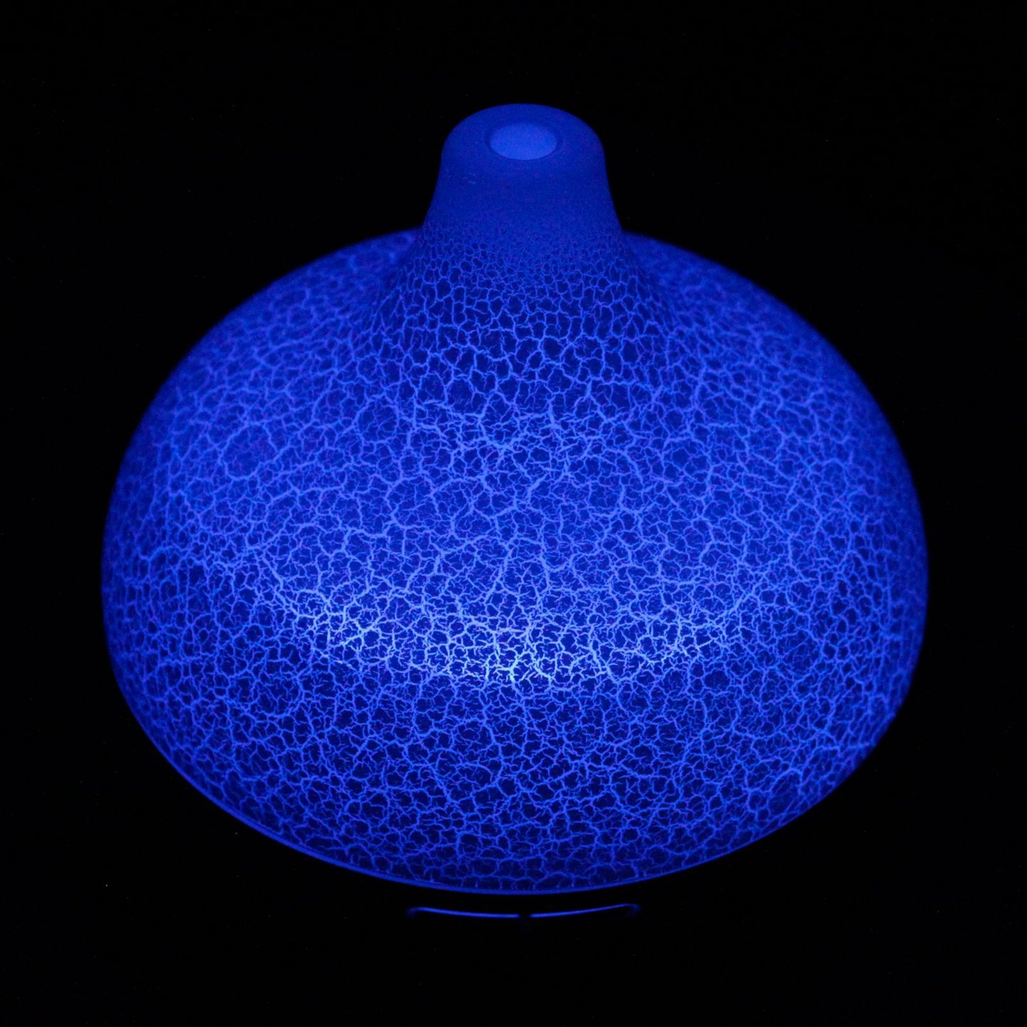 Difusor Santorini 400ml con acabado efecto craquelado e iluminación LED azul brillante sobre fondo negro.