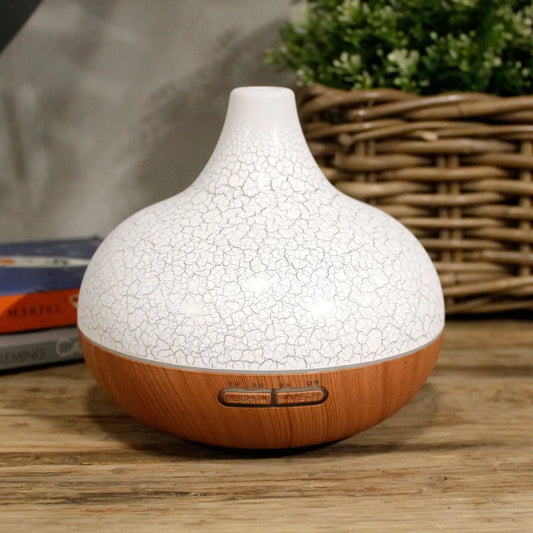 Difusor Santorini blanco con textura agrietada y base de madera, con botones de control integrados y diseño elegante.