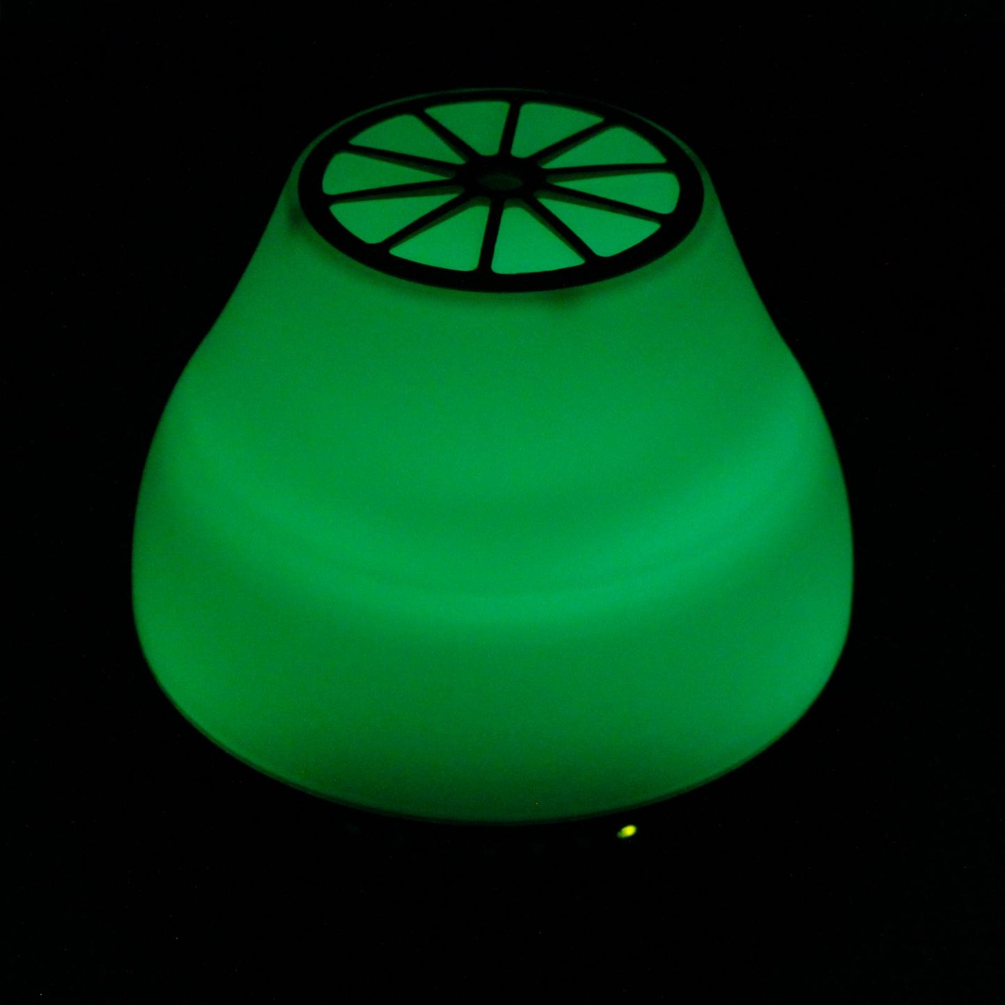 Difusor de aroma Viennese, forma cónica, luz LED verde brillante y rejilla superior sobre fondo negro.