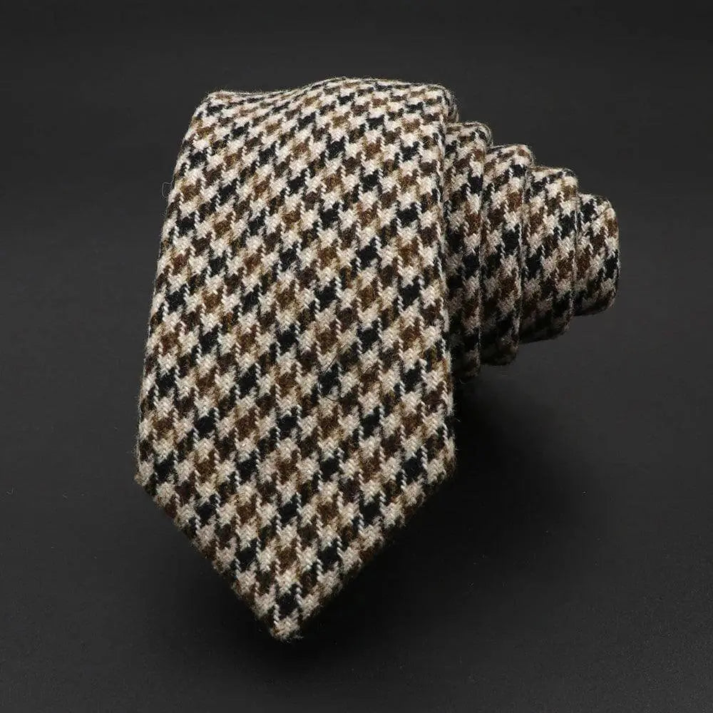 Corbata de lana con patrón de pata de gallo en tonos marrón, negro y crema sobre fondo oscuro.