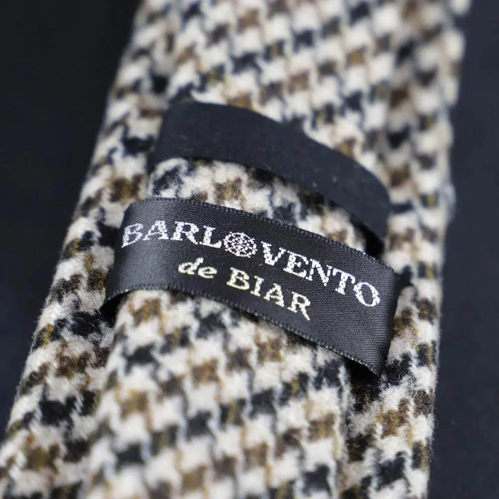 Corbata de lana con estampado pata de gallo en tonos marrón, negro y crema, con etiqueta central cosida.