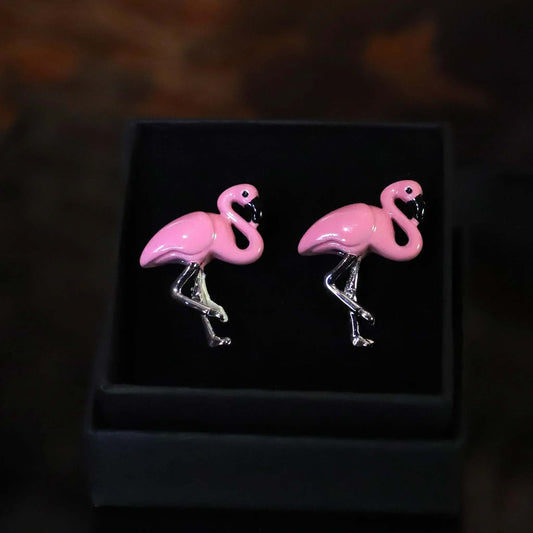 Gemelos modernos de flamencos rosas esmaltados con patas plateadas brillante, presentados en una caja de regalo negra.