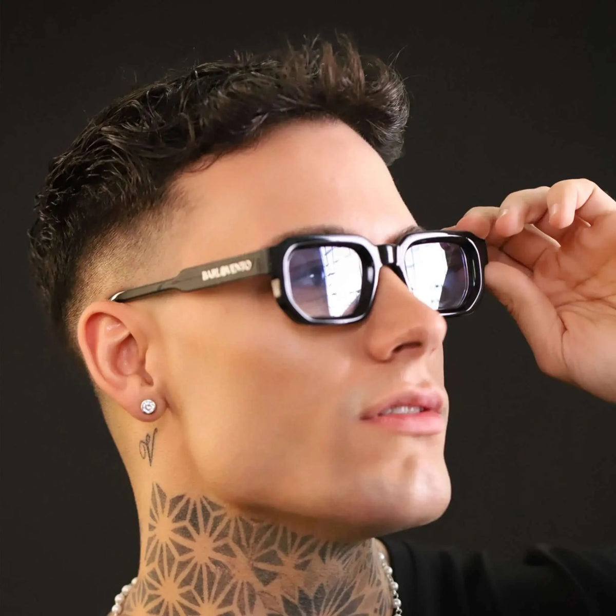Gafas de sol rectangulares con marco grueso negro y lentes tintados en azul, estilo moderno y urbano.