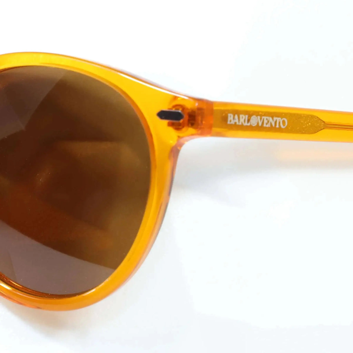 Gafas de sol de montura redonda en acetato naranja translúcido con acabado brillante y cristales oscuros.
