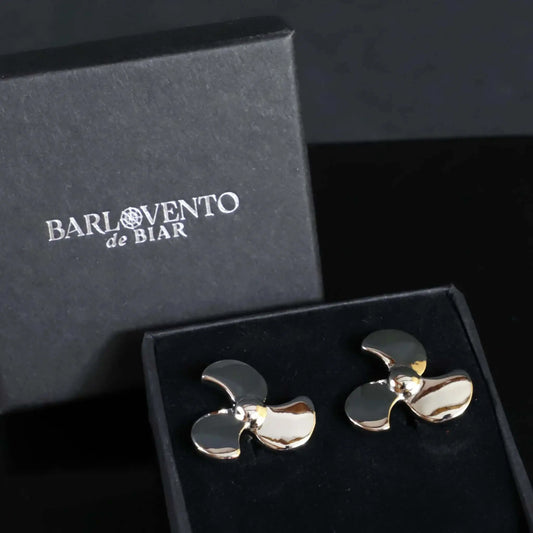 Gemelos de camisa plateados con forma de hélice de barco, acabado pulido brillante, presentados en caja de regalo negra.