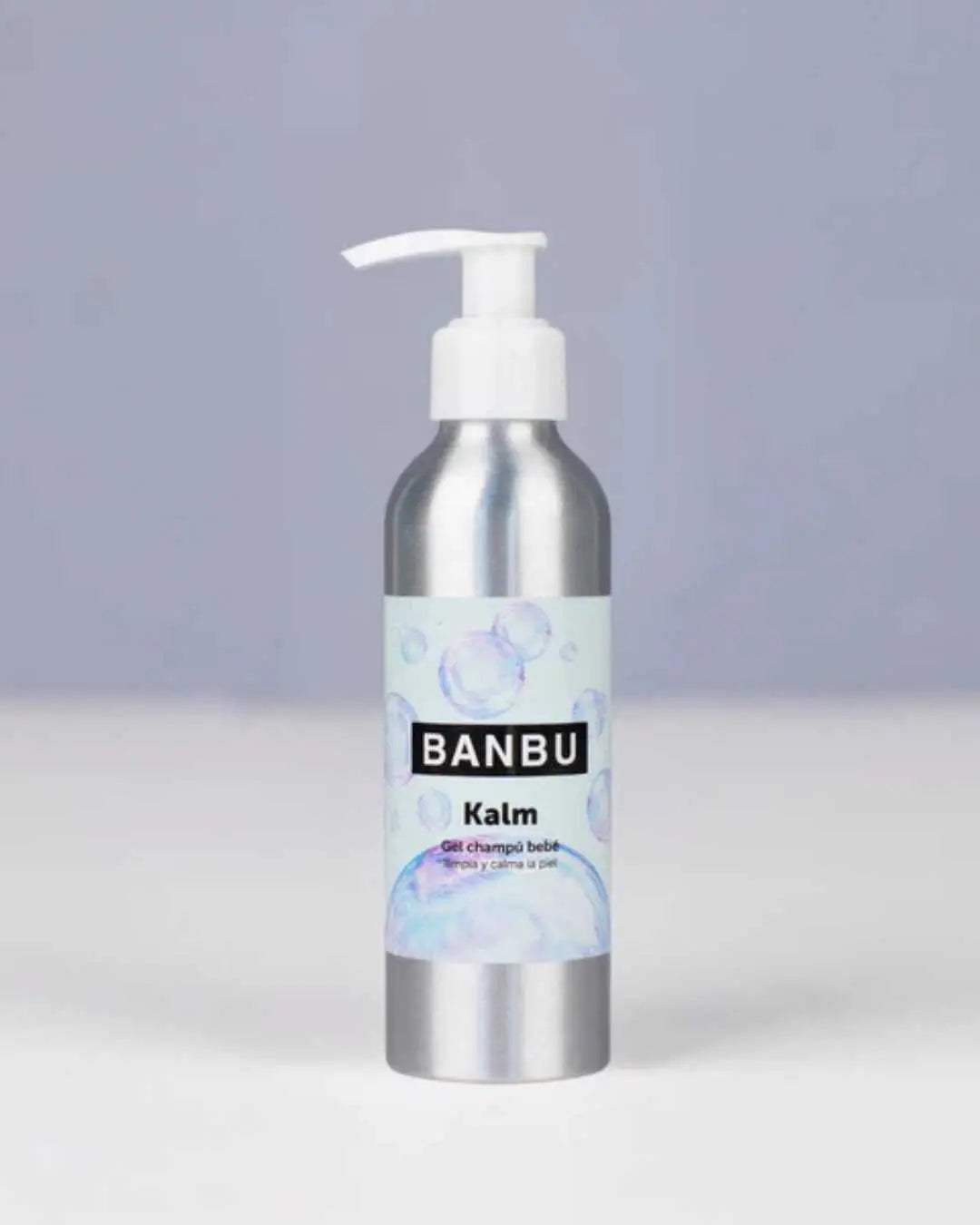 Botella de aluminio con dispensador blanco de champú-gel para bebé Banbu Kalm, etiqueta con burbujas sobre fondo gris.