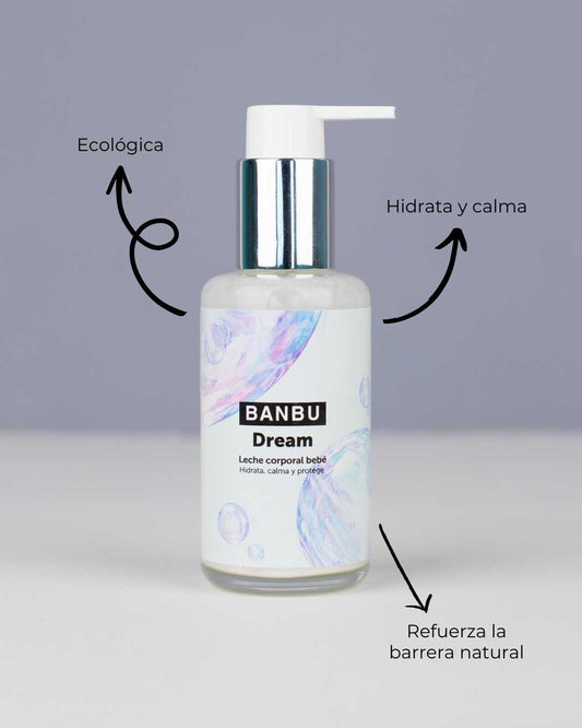 Envase de leche corporal Banbu Dream para bebé con dosificador, sobre fondo gris y etiquetas con beneficios.