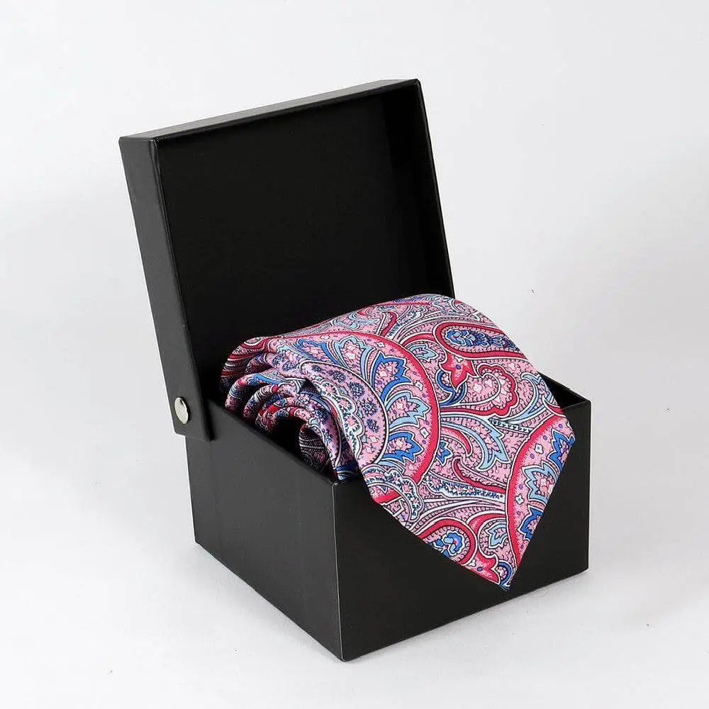 Corbata de seda con estampado paisley en tonos rosa y azul dentro de una elegante caja negra de presentación.