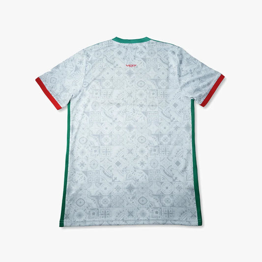 Maillot VO7 blanc à motifs azulejos gris, col et bandes latérales verts, finitions rouges aux manches. Dos technique.