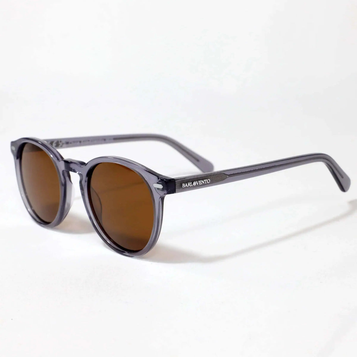 Gafas de sol redondas con montura de acetato gris cristal transparente y lentes oscuras color café, estilo vintage.