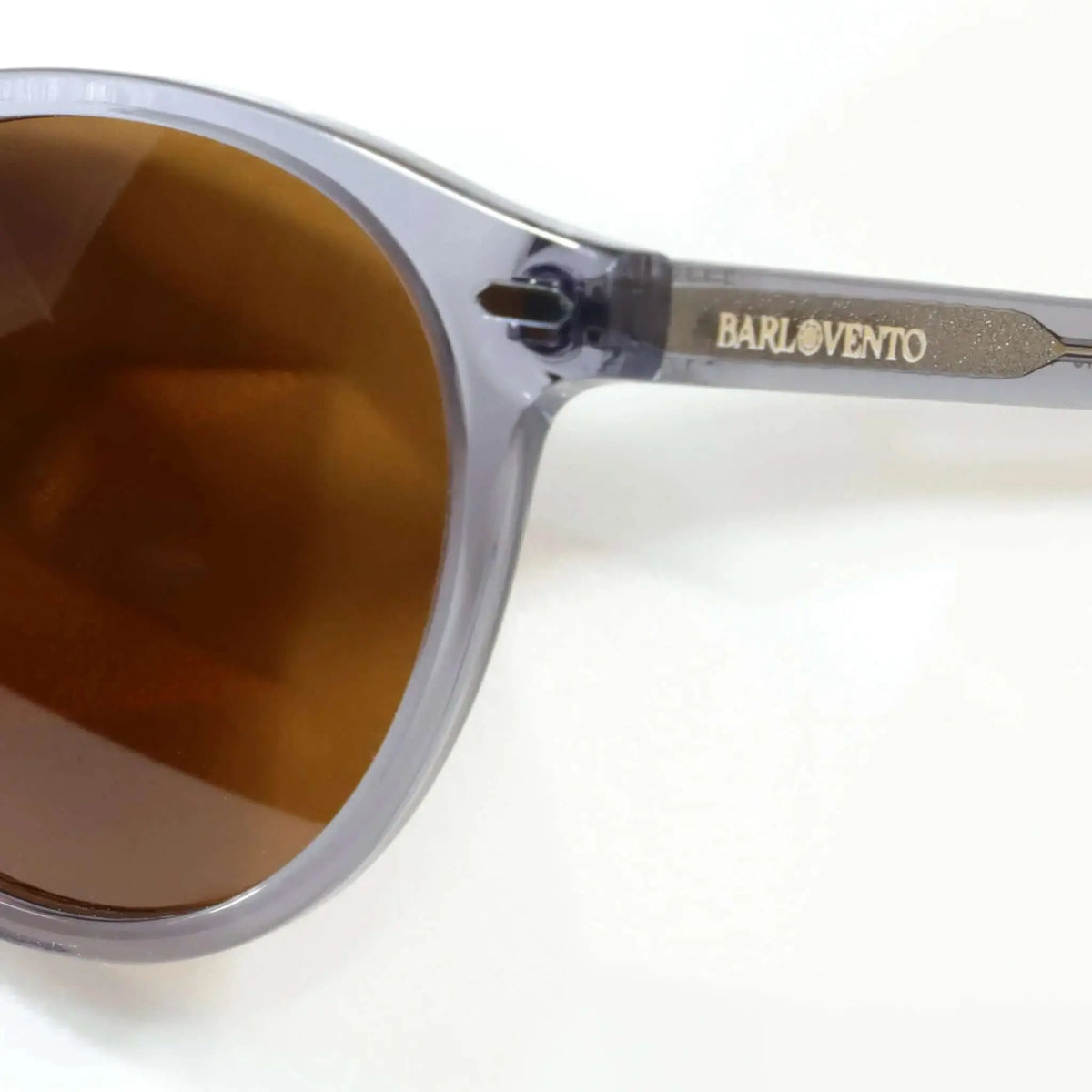 Gafas de sol redondas con montura de acetato gris cristal y lentes oscuras de estilo moderno y elegante.