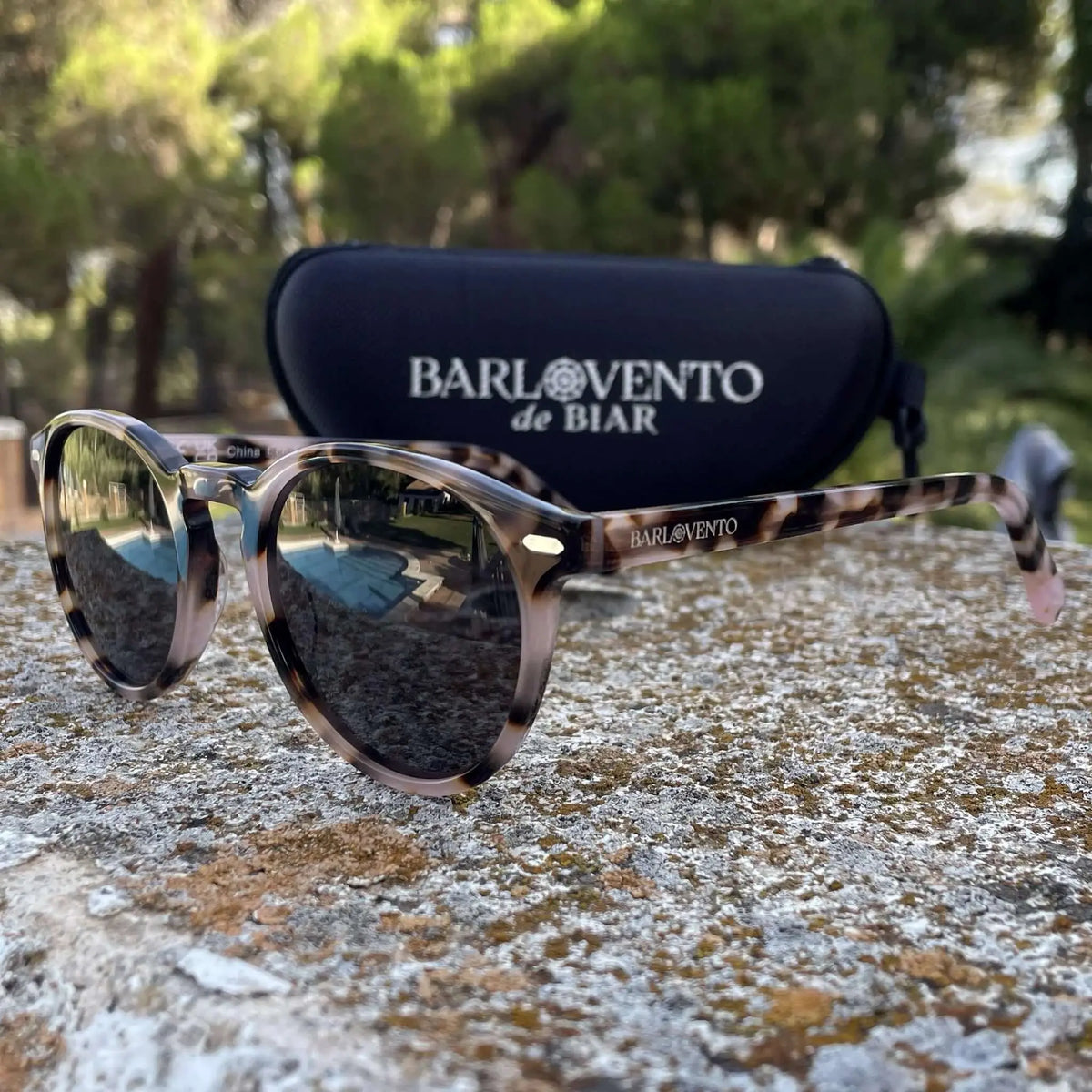 Gafas de sol redondas con montura de acetato efecto carey en tonos marrones y estuche protector en exteriores.