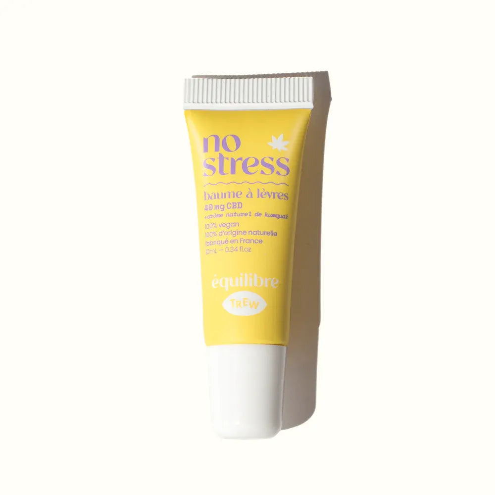 Yellow lip balm tube with purple text reading "no stress" and a white screw cap on a white background.