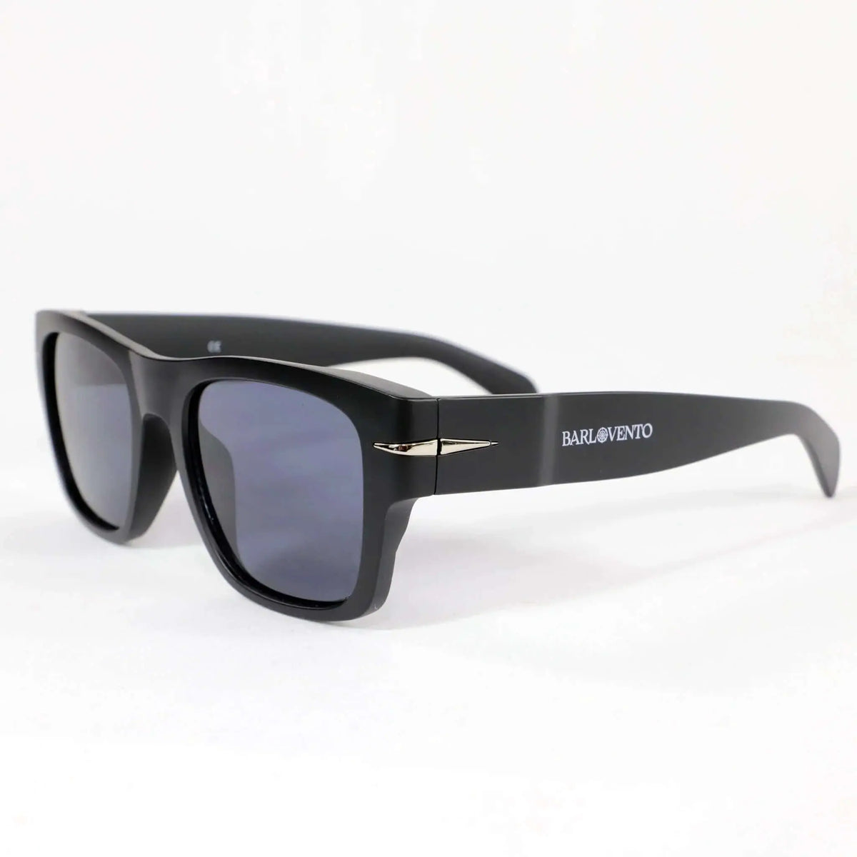 Gafas de sol negras cuadradas con acabado mate, cristales oscuros UV400 y detalle de inserción metálica en patillas.