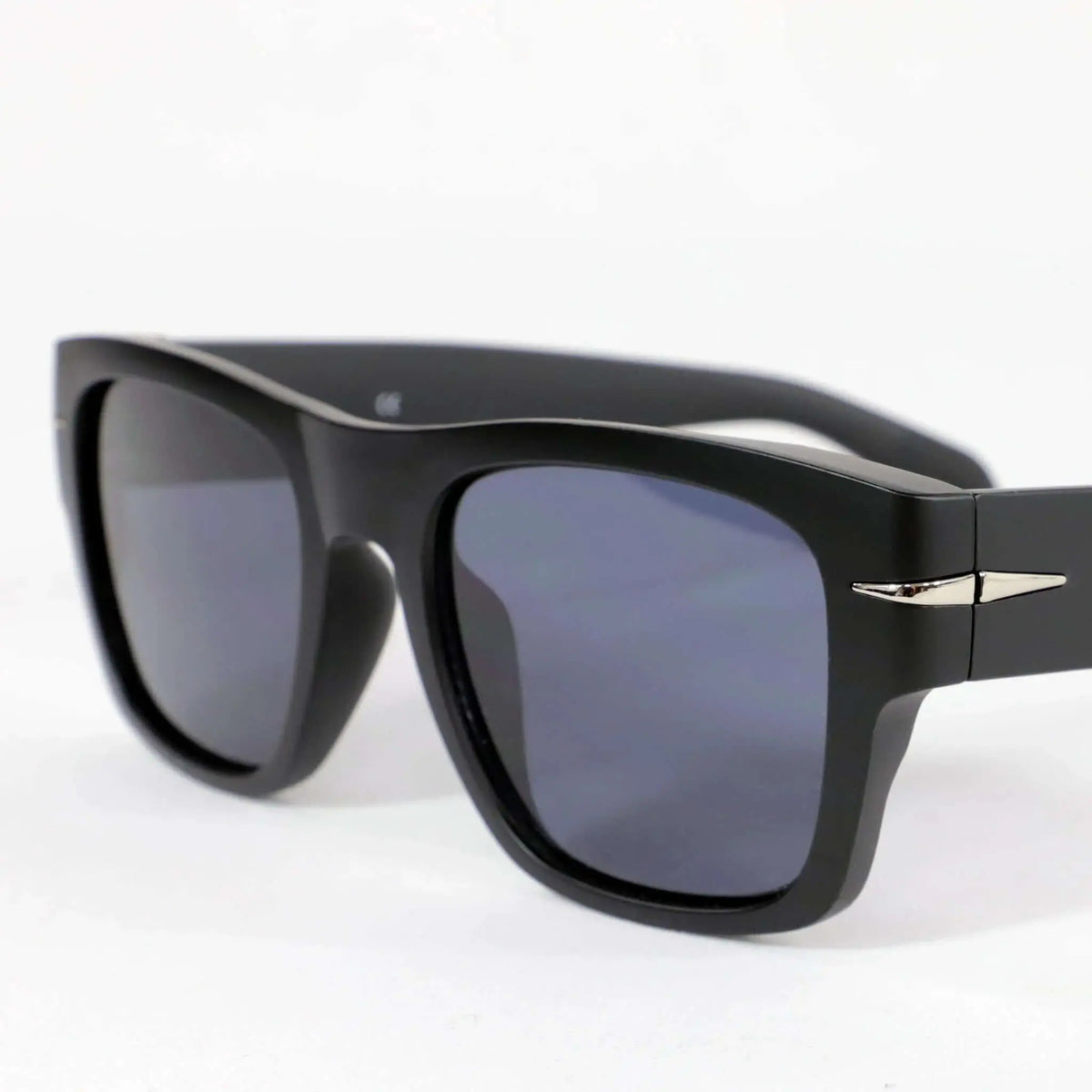 Gafas de sol cuadradas negras con acabado mate, lentes oscuras y detalle metálico lateral, diseño moderno unisex.