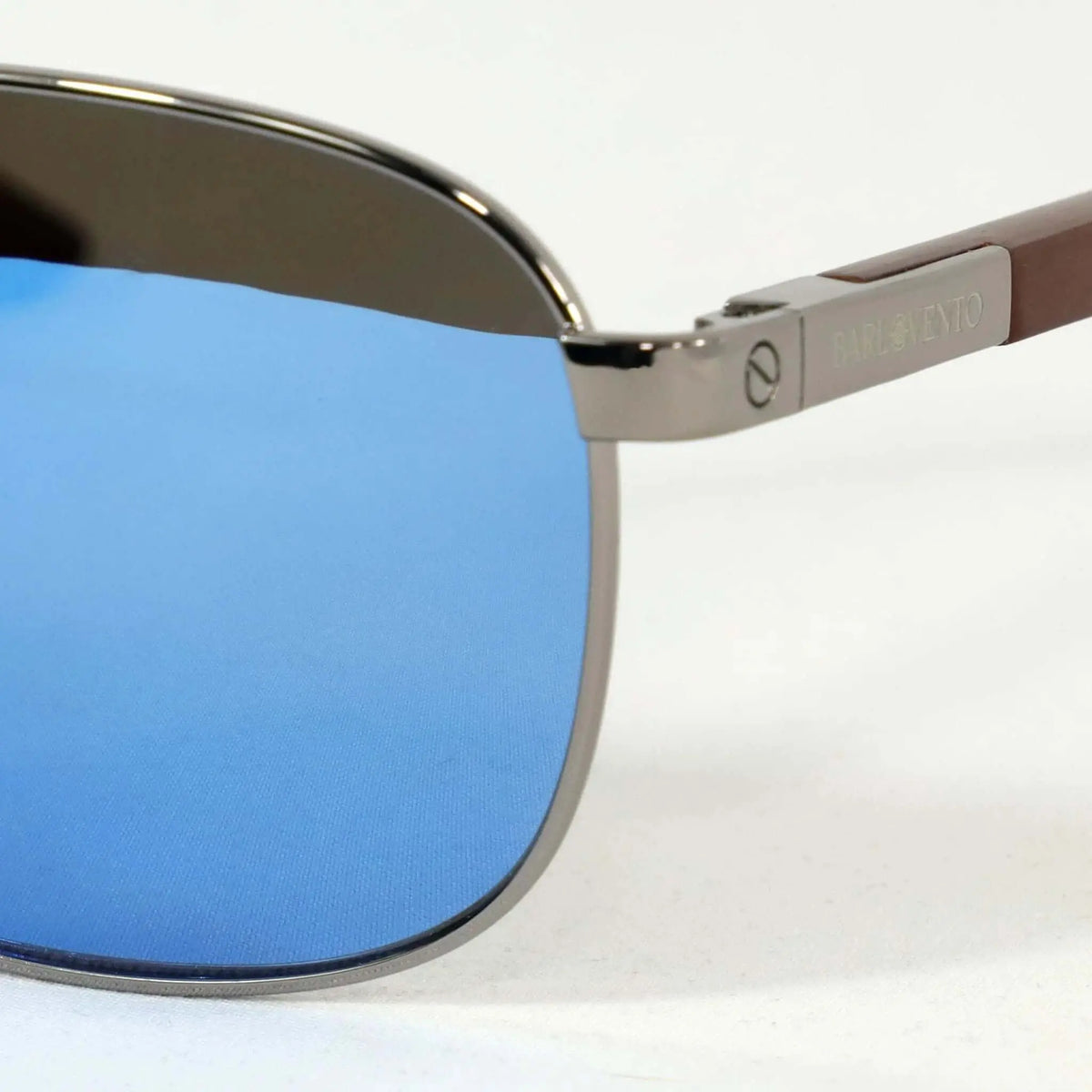 Gafas de sol con montura metálica, lentes azules espejadas y patillas de madera de diseño elegante.