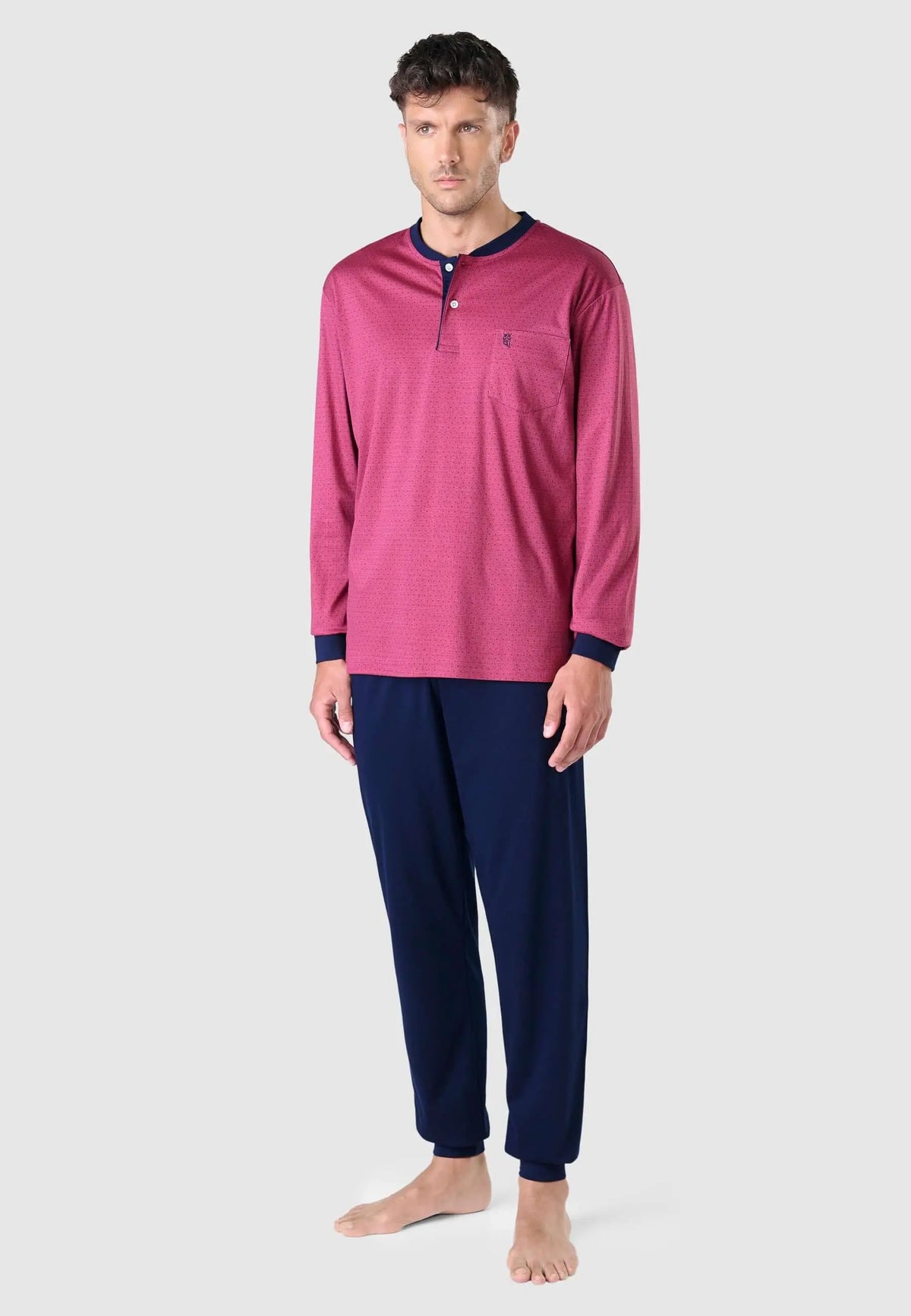 Pijama largo de hombre: camiseta roja estampada con botones y bolsillo, y pantalón azul marino liso. Marca El Búho.