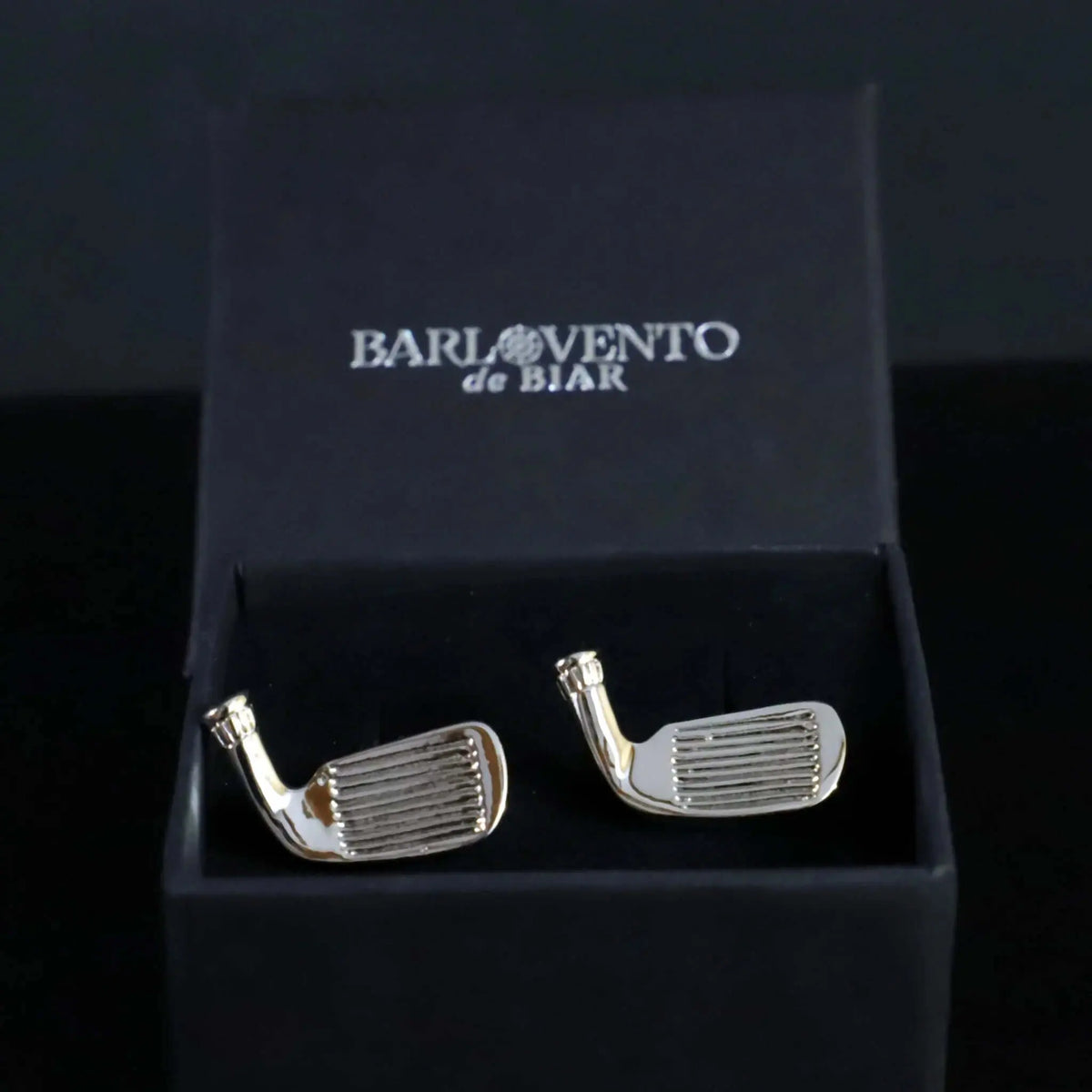 Gemelos plateados con forma de palo de golf, acabado brillante, presentados en una elegante caja negra de regalo.