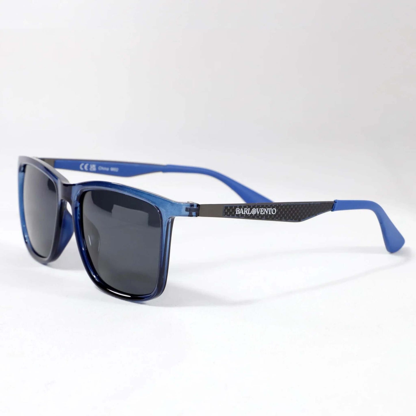 Gafas de sol rectangulares con montura azul translúcida, lentes oscuras y varillas con acabado estilo fibra de carbono.