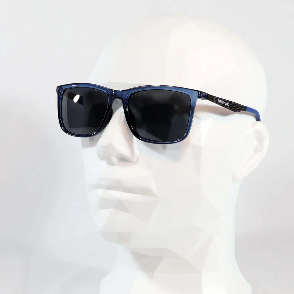 Gafas de sol rectangulares con montura de acetato azul translúcido y cristales oscuros sobre maniquí blanco.