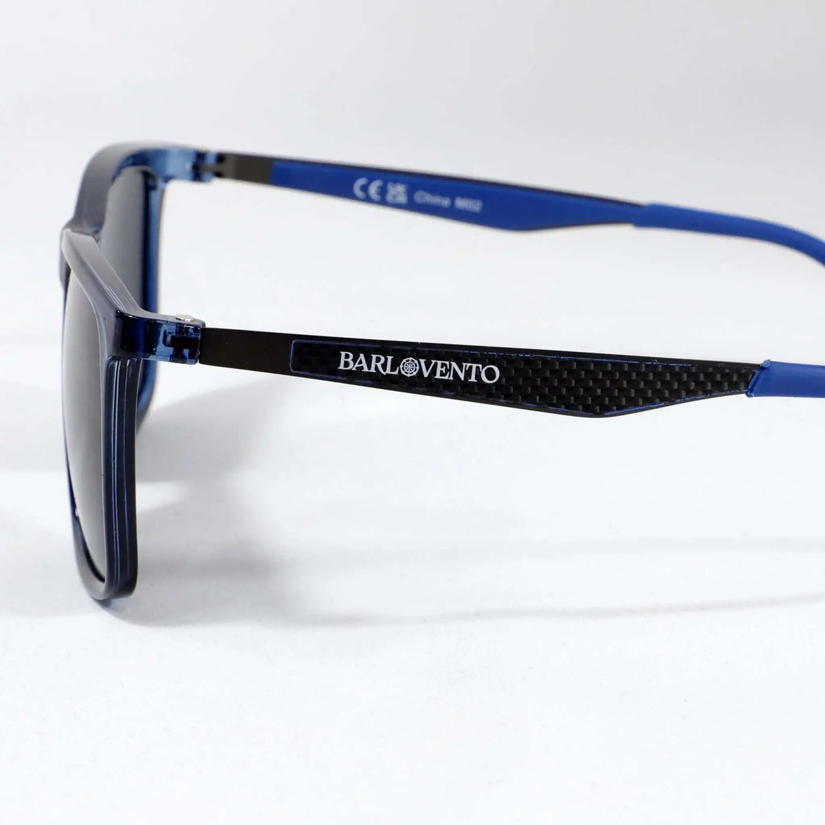 Gafas de sol deportivas con montura azul brillante y patillas con detalle de fibra de carbono sobre fondo blanco.