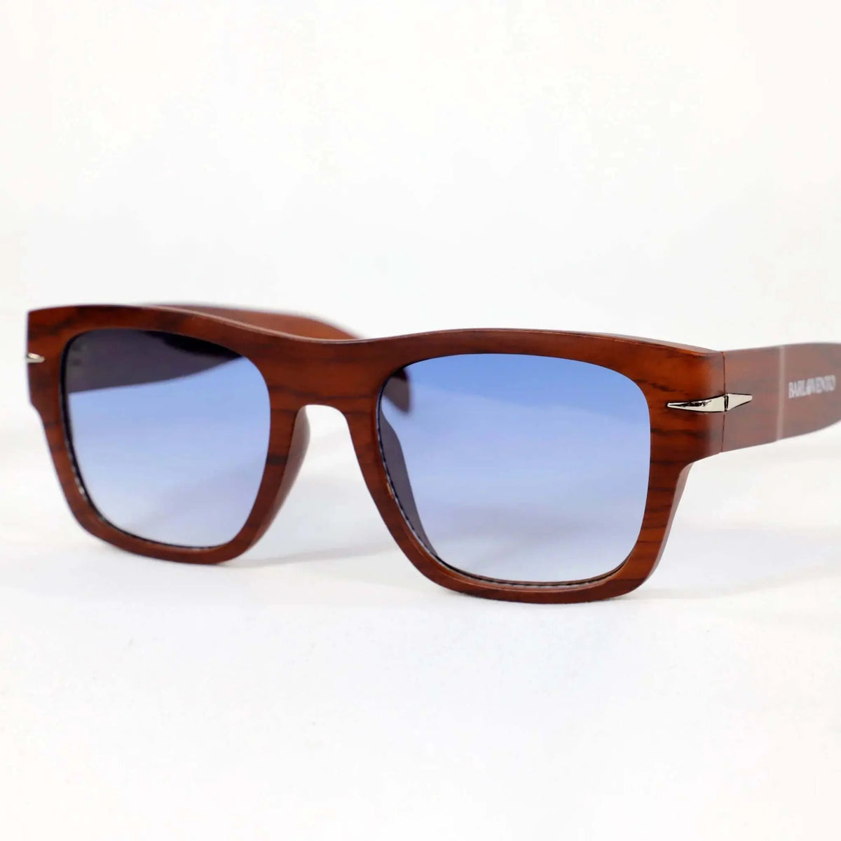 Gafas de sol cuadradas con montura estilo madera marrón y lentes azules degradadas sobre fondo blanco.