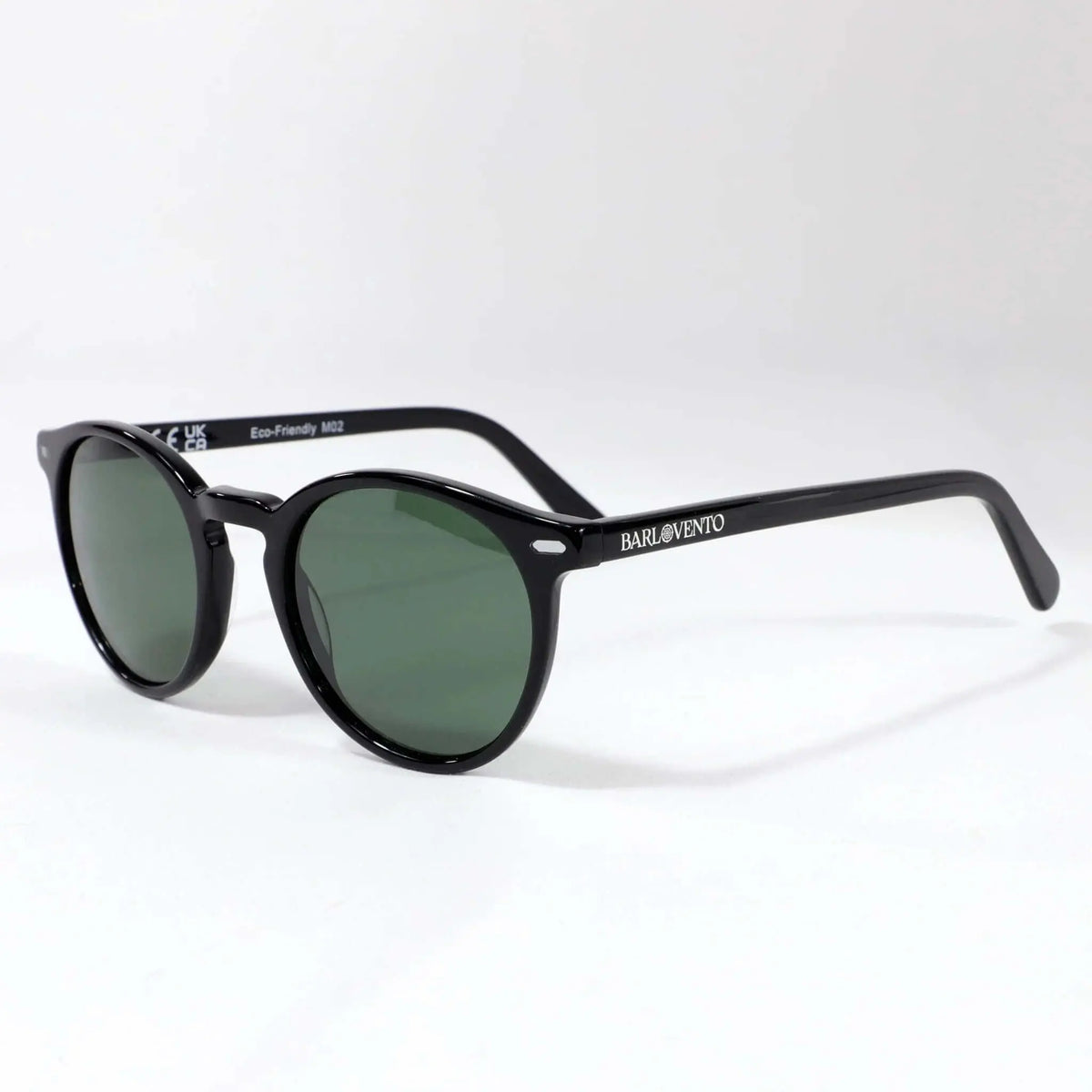 Gafas de sol unisex con montura redonda de acetato negro brillante y lentes polarizadas en tono verde oscuro.