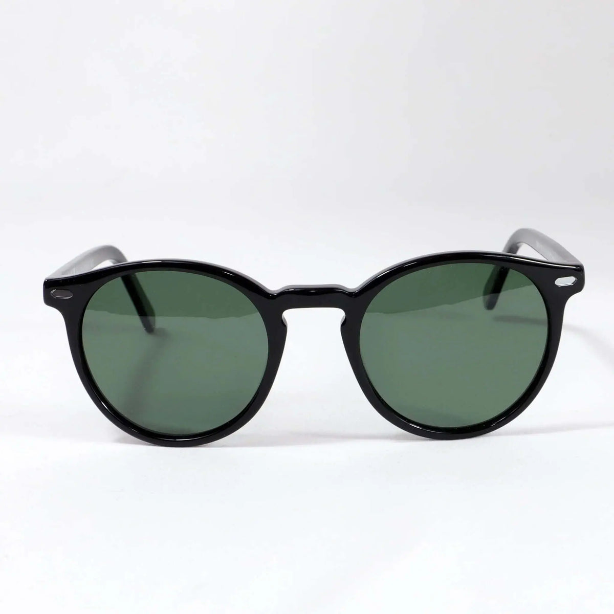 Gafas de sol unisex con montura negra redondeada, acabado brillante y lentes polarizadas en color verde oscuro.