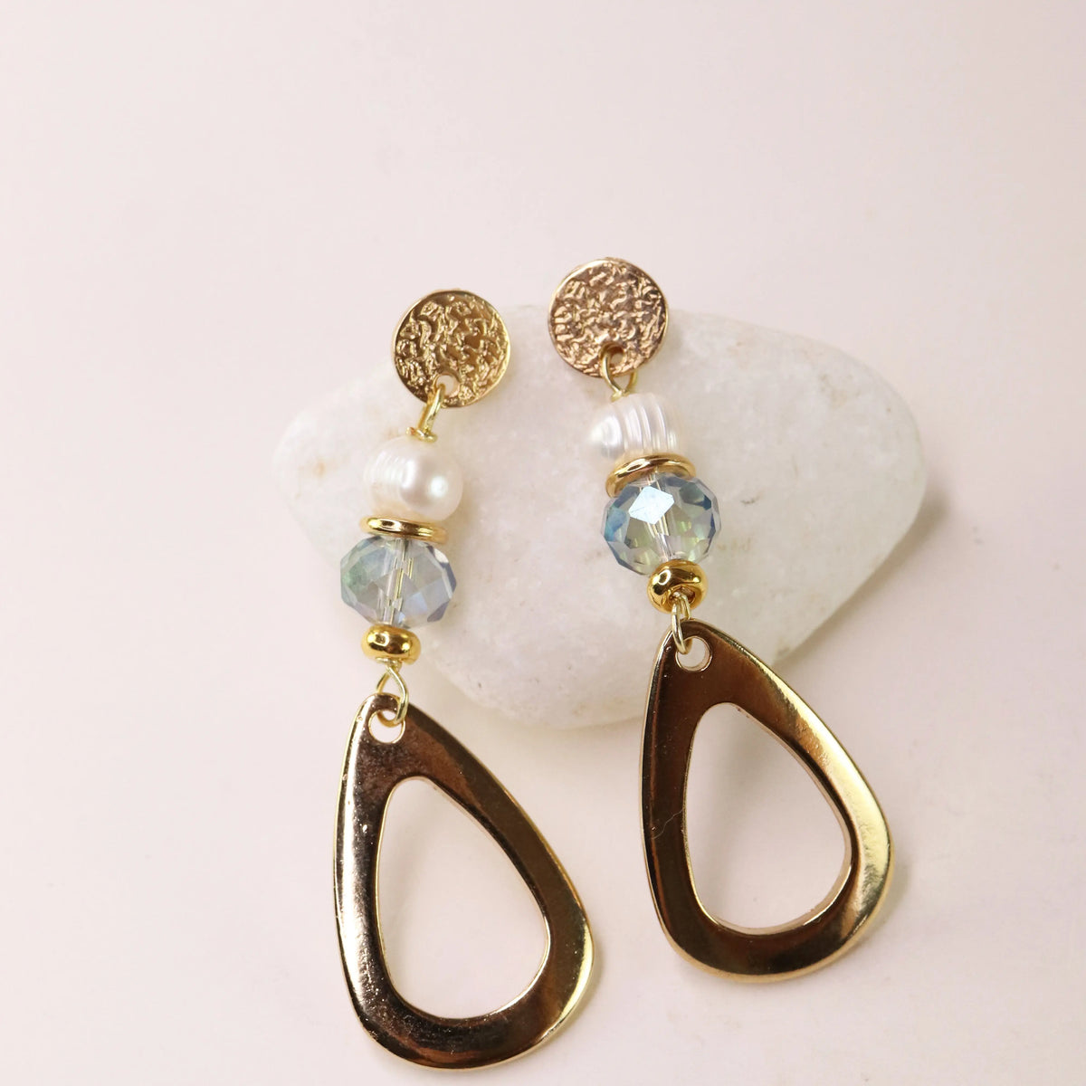 Pendientes dorados con cuentas de cristal azul y perlas, diseño moderno y elegante, perfectos para ocasiones especiales.
