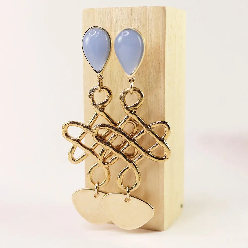 Pendientes de metal dorado con piedras azules en forma de gota y diseño moderno.