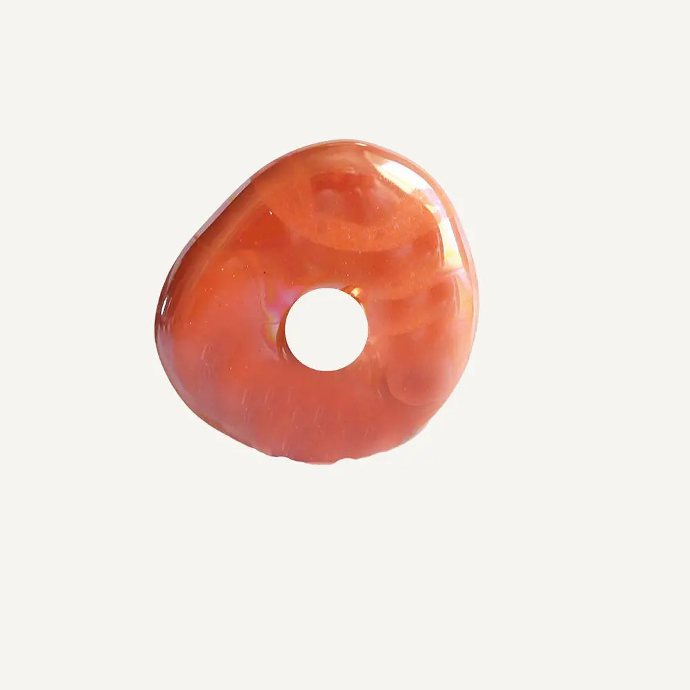 Donut de resina color rosa, acabado brillante, estilo moderno y único para decoración o joyería.