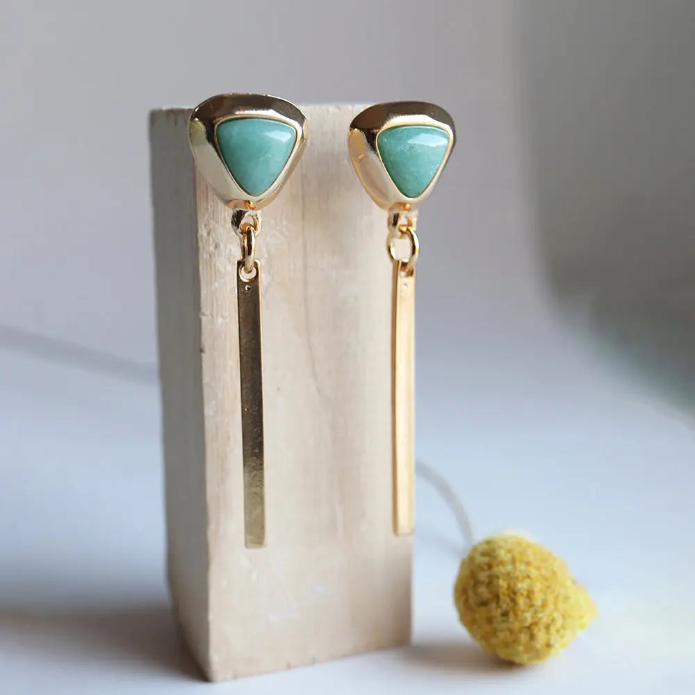 Pendientes dorados con agujas y piedra verde, estilo moderno y elegante, perfectos para cualquier ocasión.