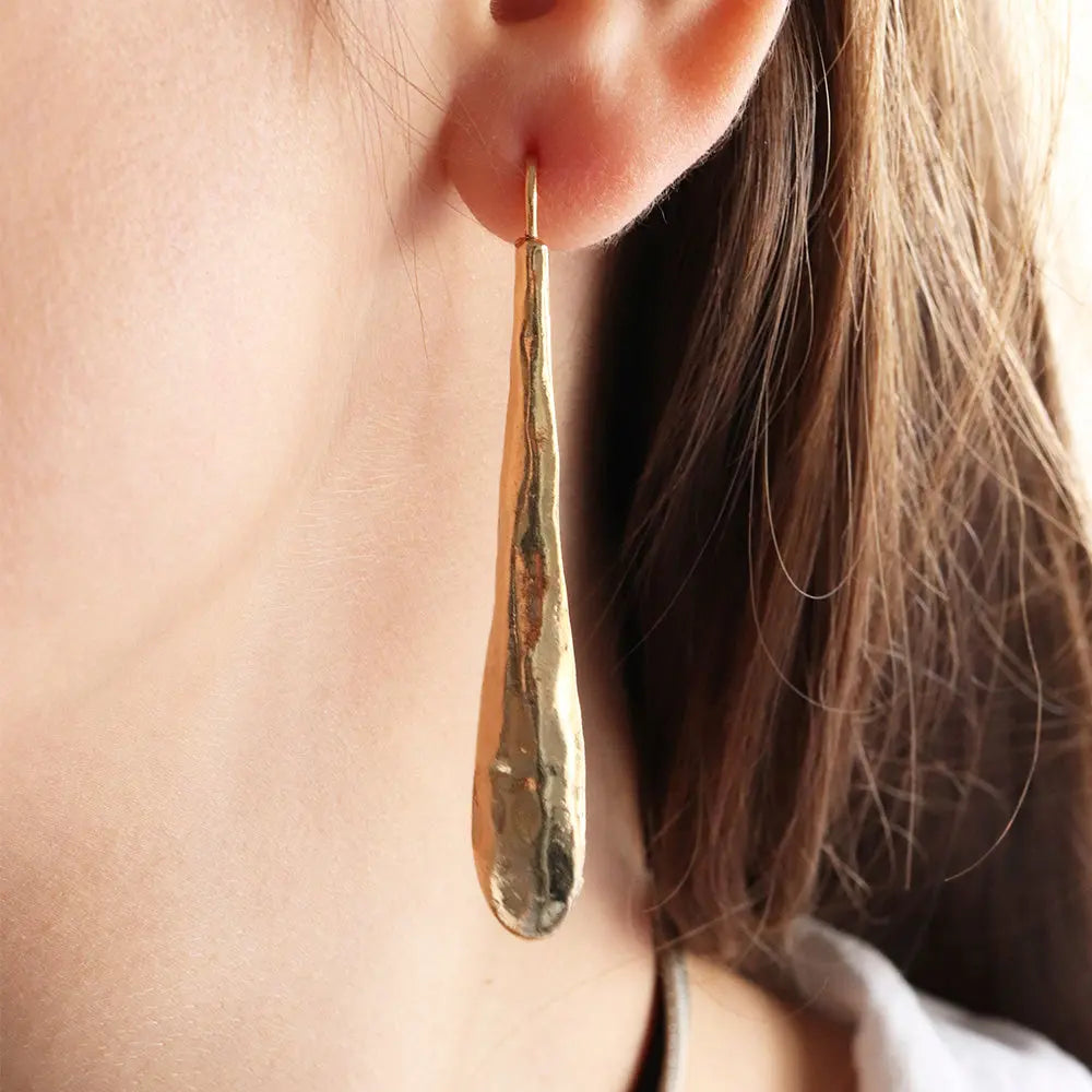 Pendientes largos de oro, diseño moderno y texturizado, perfectos para realzar cualquier atuendo elegante.