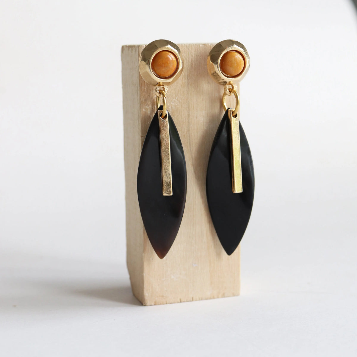 Pendientes elegantes de acero dorado con detalle en ámbar y charm negro en forma de hoja. Ideal para ocasiones especiales.