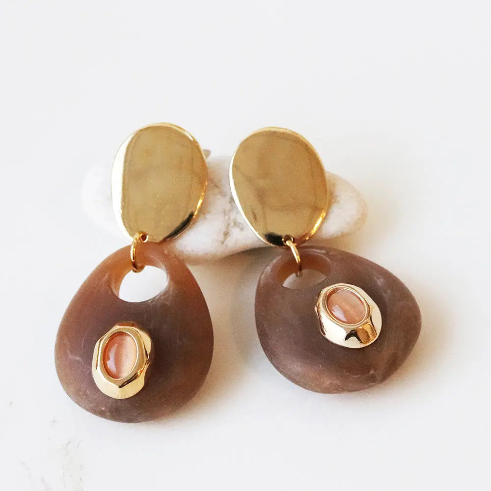 Pendientes de resina marrón con detalles dorados y piedra rosa, estilo moderno y elegante.