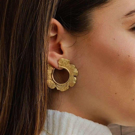 Pendientes dorados de acero inoxidable con diseño de flor, perfectos para dar un toque elegante y moderno.