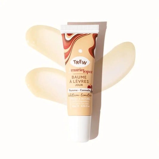 A squeeze tube of Pomme Cannelle lip balm with a brown marbled design, shown against two swipes of clear balm.