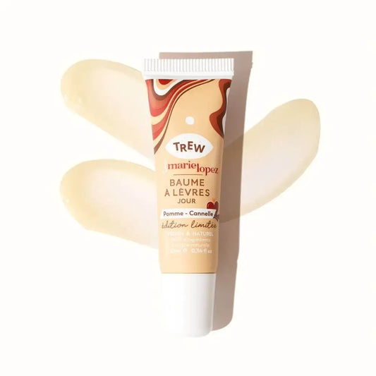 A squeeze tube of Pomme Cannelle lip balm with a brown marbled design, shown against two swipes of clear balm.