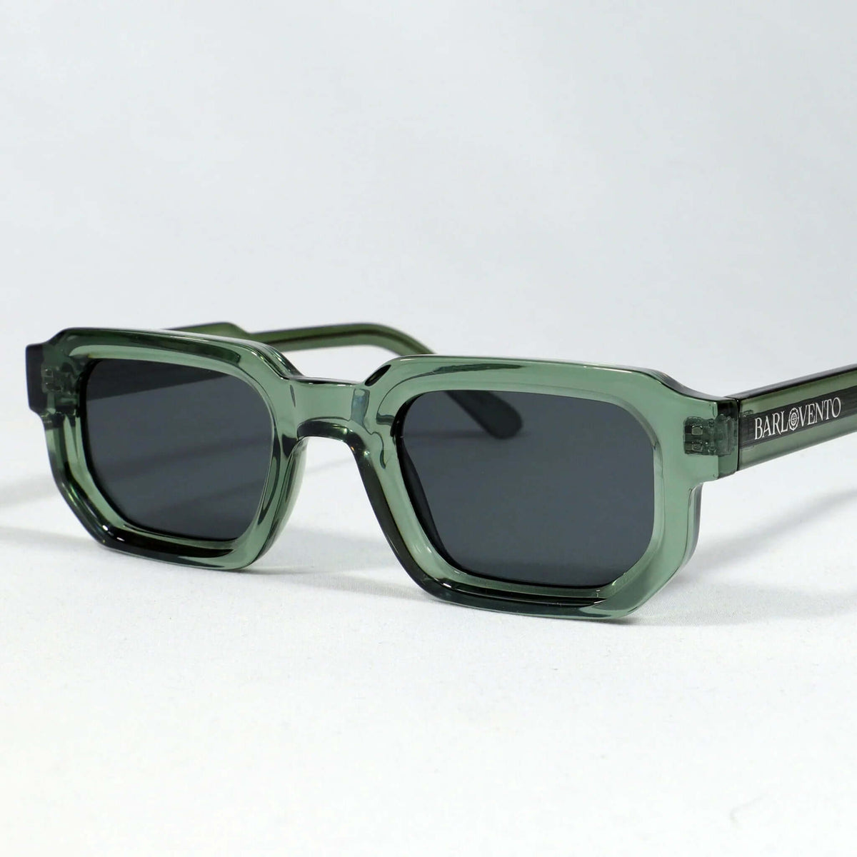 Gafas de sol rectangulares con marco de acetato translúcido color verde y lentes oscuros de estilo moderno.