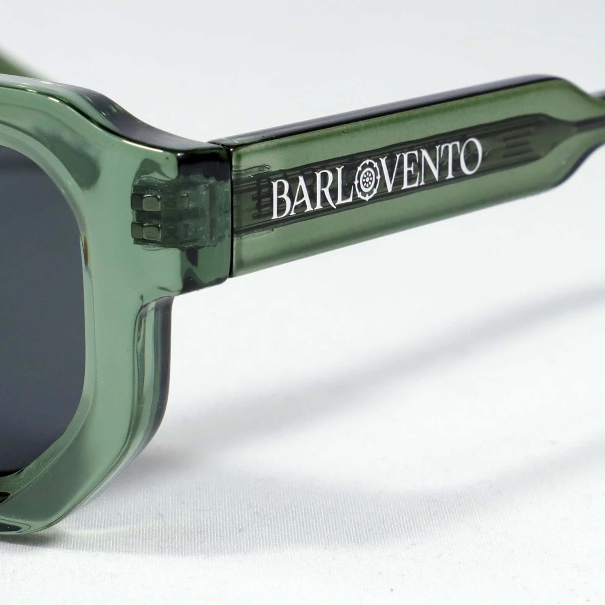 Gafas de sol con montura de acetato verde translúcido y lentes oscuras, diseño moderno y elegante.