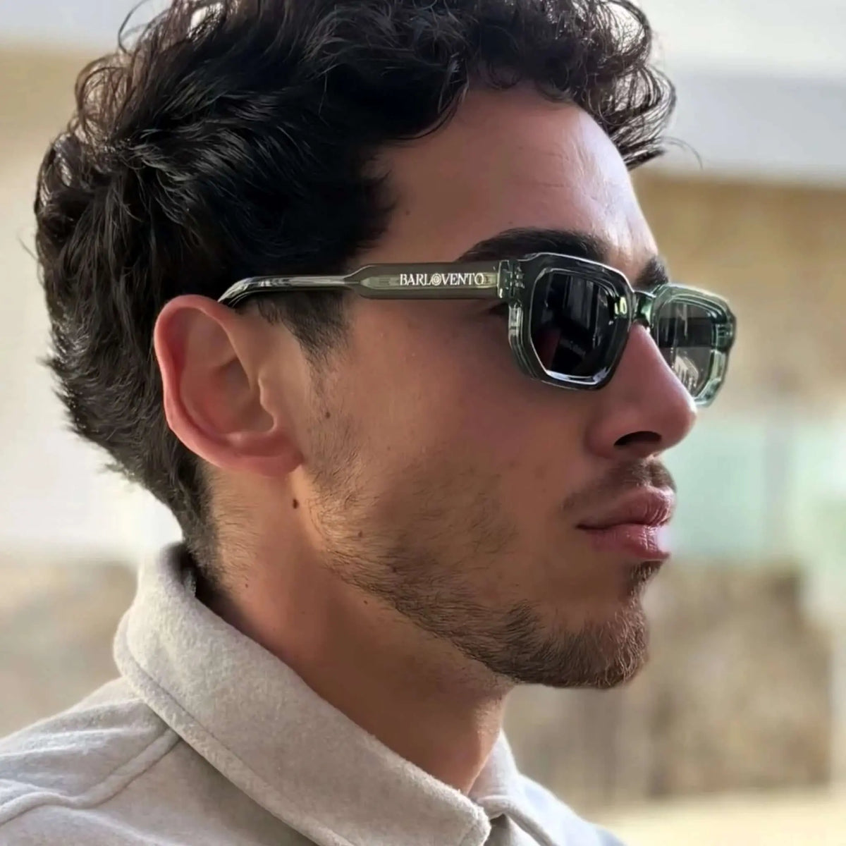 Gafas de sol de montura rectangular gruesa en tono verde translúcido y lentes oscuras, estilo moderno y audaz.