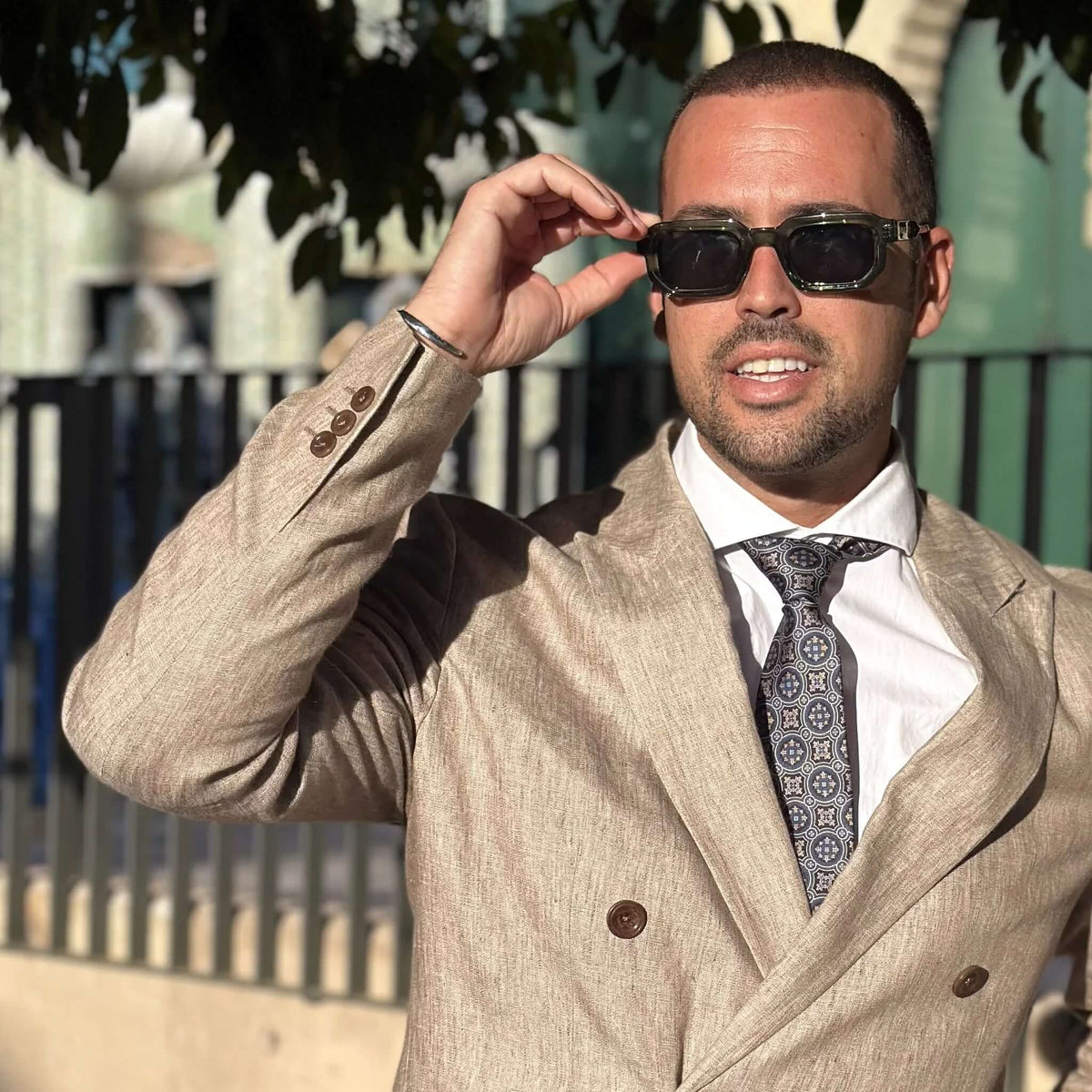 Gafas de sol con montura gruesa de acetato verde traslúcido y cristales oscuros, estilo cuadrado y elegante.