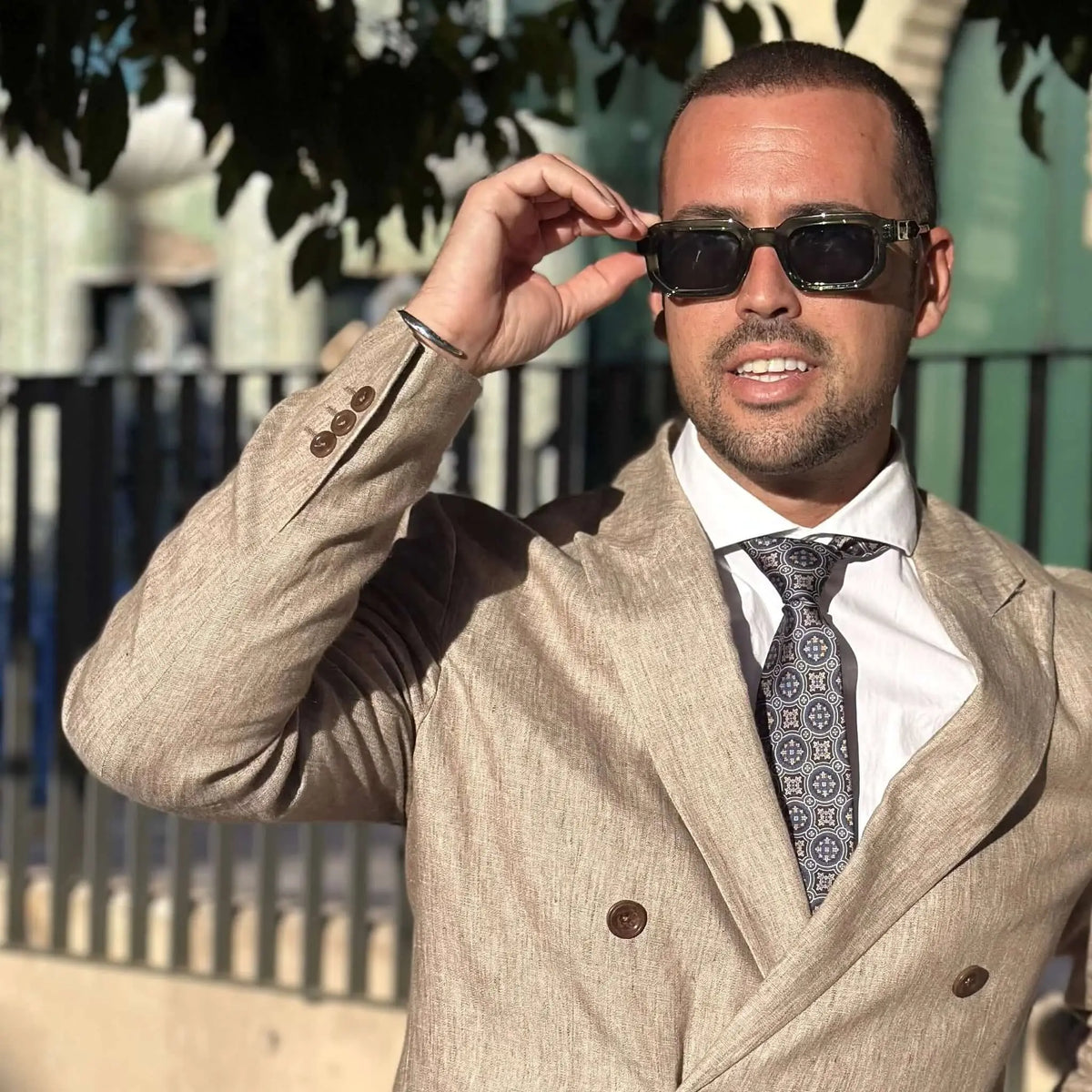Gafas de sol con montura gruesa de acetato verde traslúcido y cristales oscuros, estilo cuadrado y elegante.