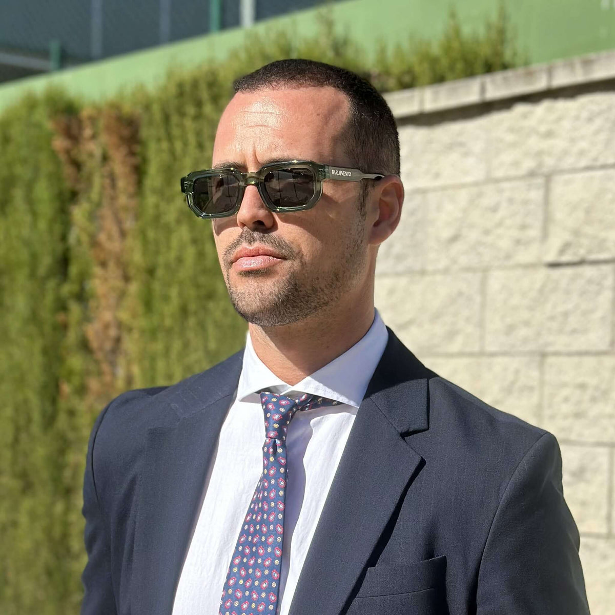 Gafas de sol de montura cuadrada en acetato verde translúcido con lentes oscuras, estilo elegante y moderno.