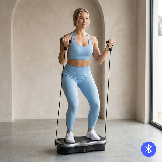 Mujer haciendo ejercicio sobre una plataforma vibratoria con bandas de resistencia.