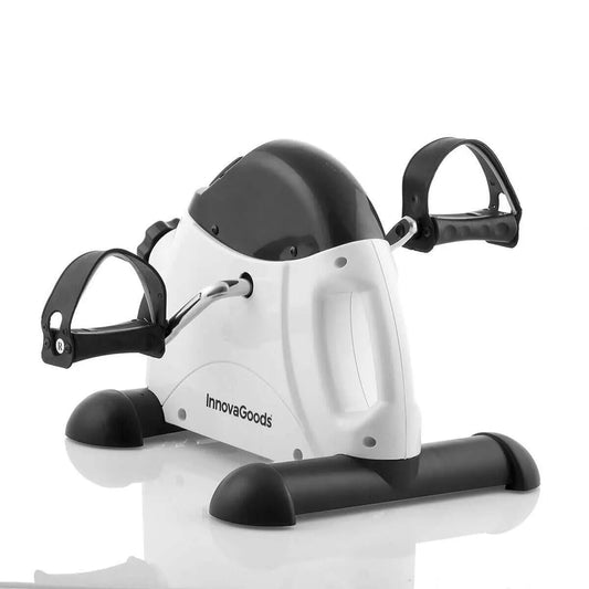 Pedaleador estático blanco y negro con pedales ajustables, ideal para ejercicio de brazos y piernas en casa.